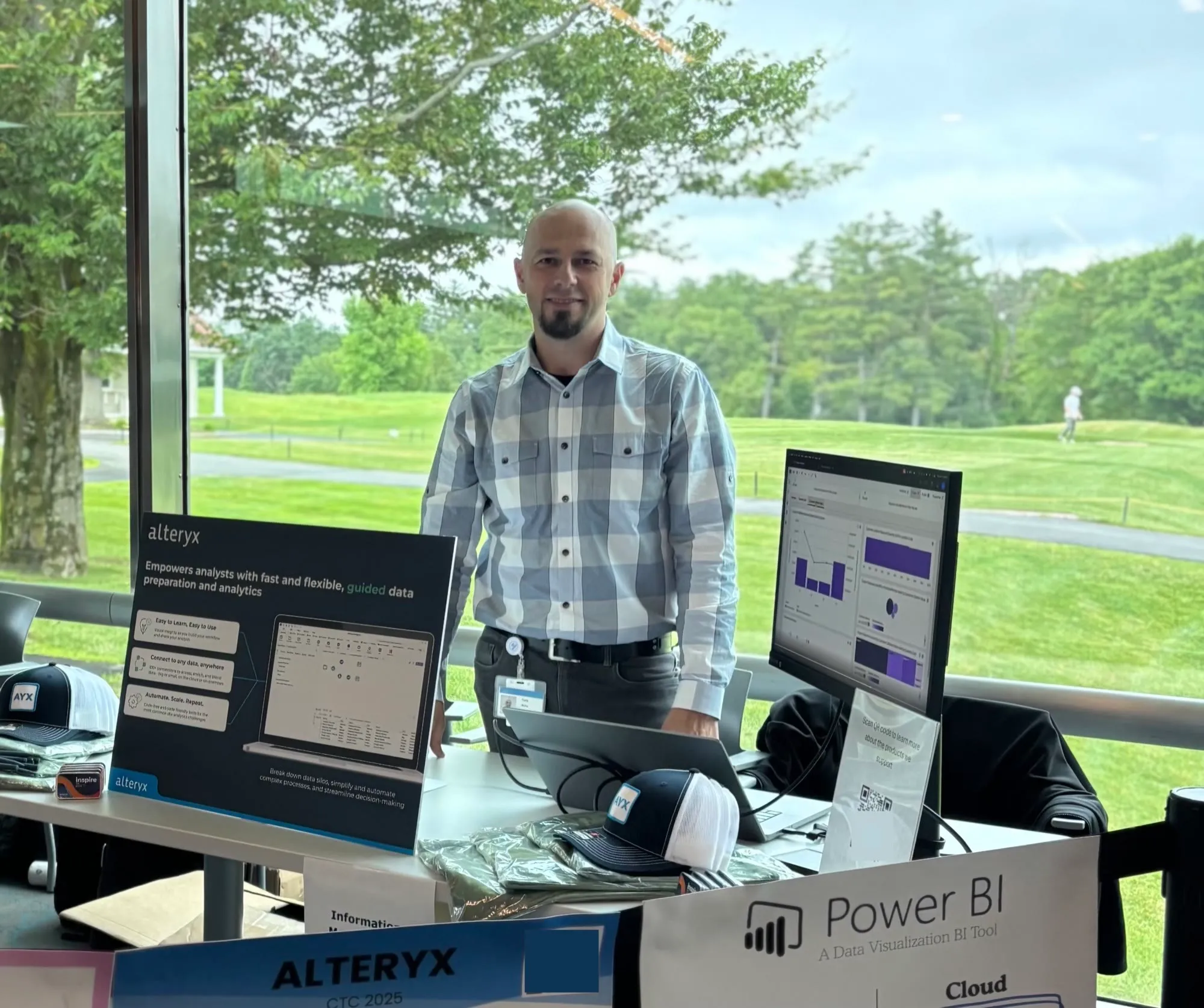 Yuriy of JY Computer Services at a data-analytics industry event, standing by dashboards
