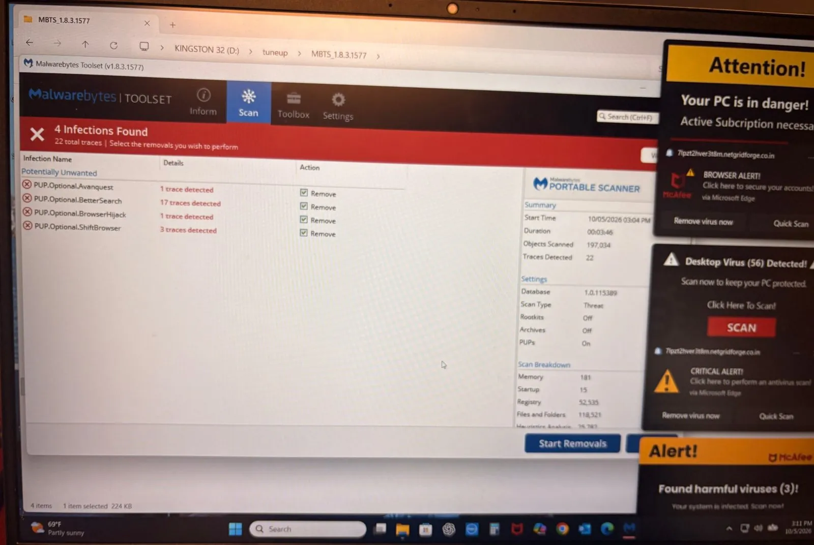 A Malwarebytes scan showing 4 infections and 22 traces on a Windows laptop while fake McAfee virus pop-ups cover the right side of the screen