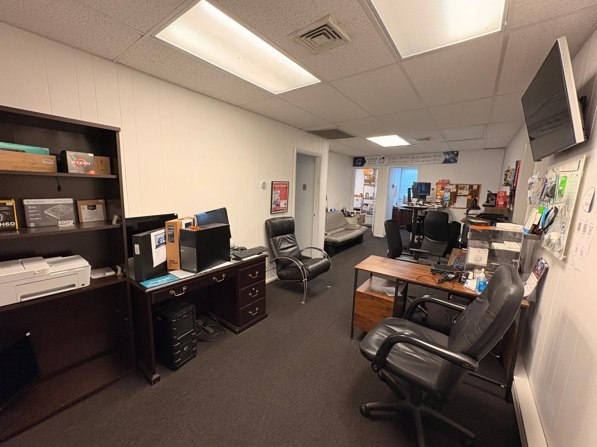 Inside the JY Computer Services shop — workbenches, parts shelves and seating